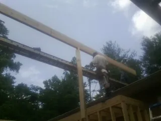 Carpenter setting a ridge beam over a new addition frame — Ice Dam Removal by Roofing Brothers in Butte Falls