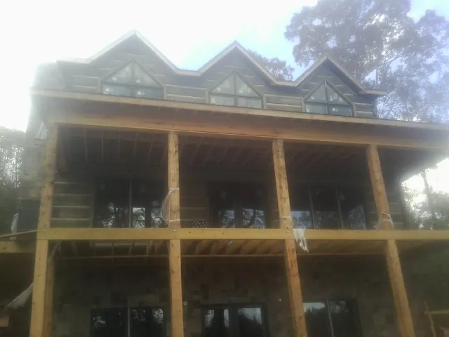 Dormers and porch framing on a large log home under construction — Roof Coating work by our crew in Butte Falls