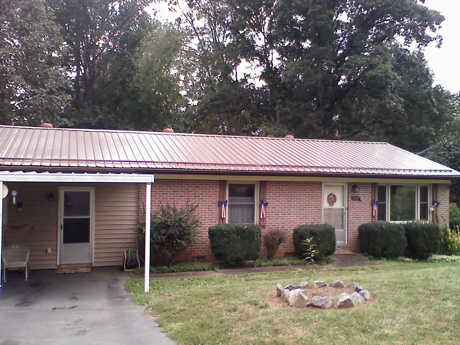 Bronze metal roof and carport on a brick ranch home — Roof Repair work by our crew in Butte Falls